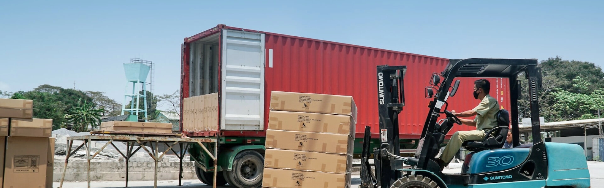 A man with a mask carrying a payload with a forklift